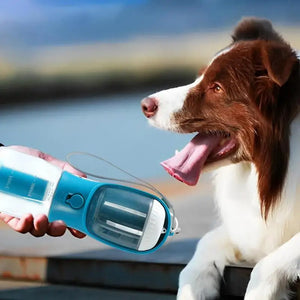 Dog drinking water from a portable blue water bottle with a blurred background
